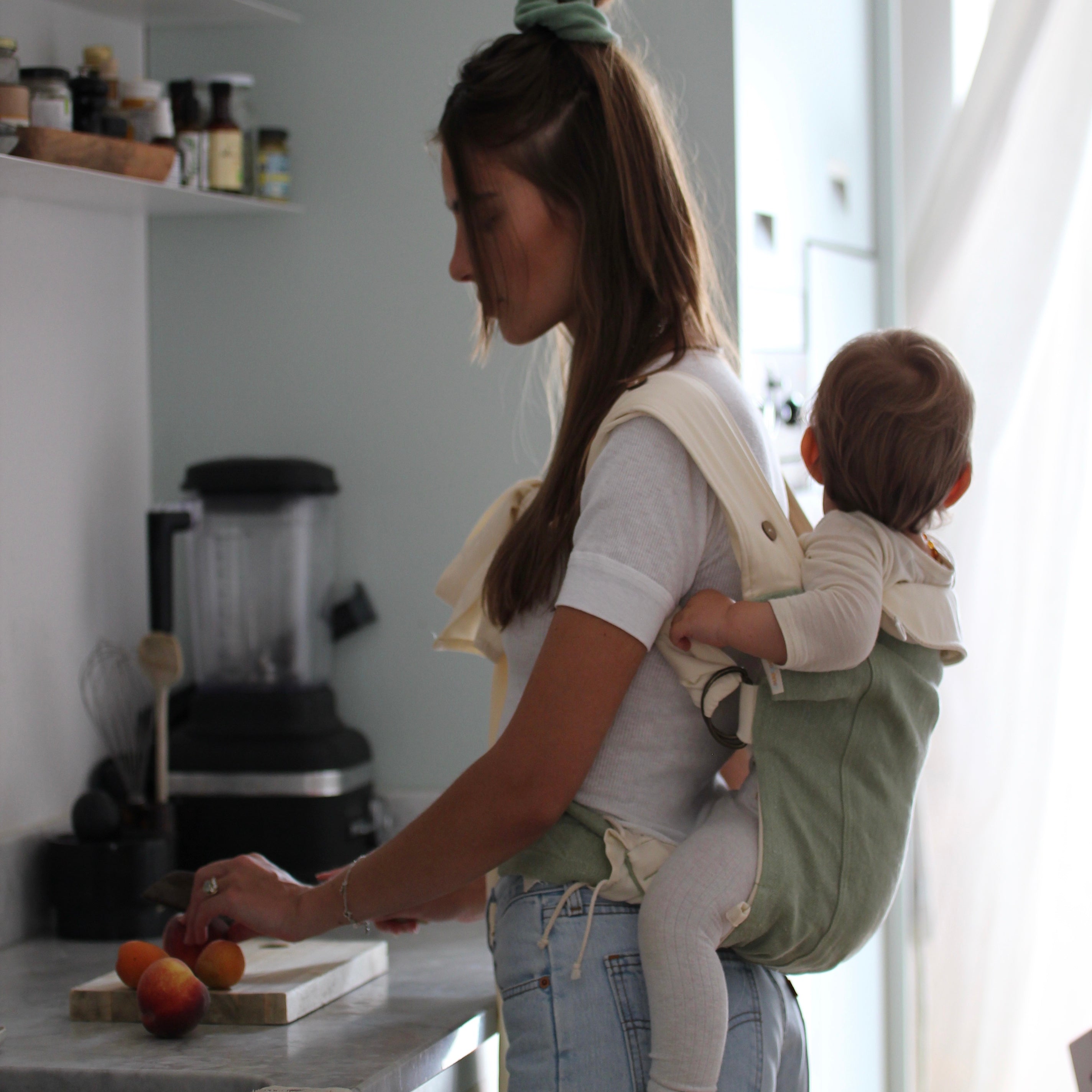 Mutter trägt Kind in Babytrage auf dem Rücken