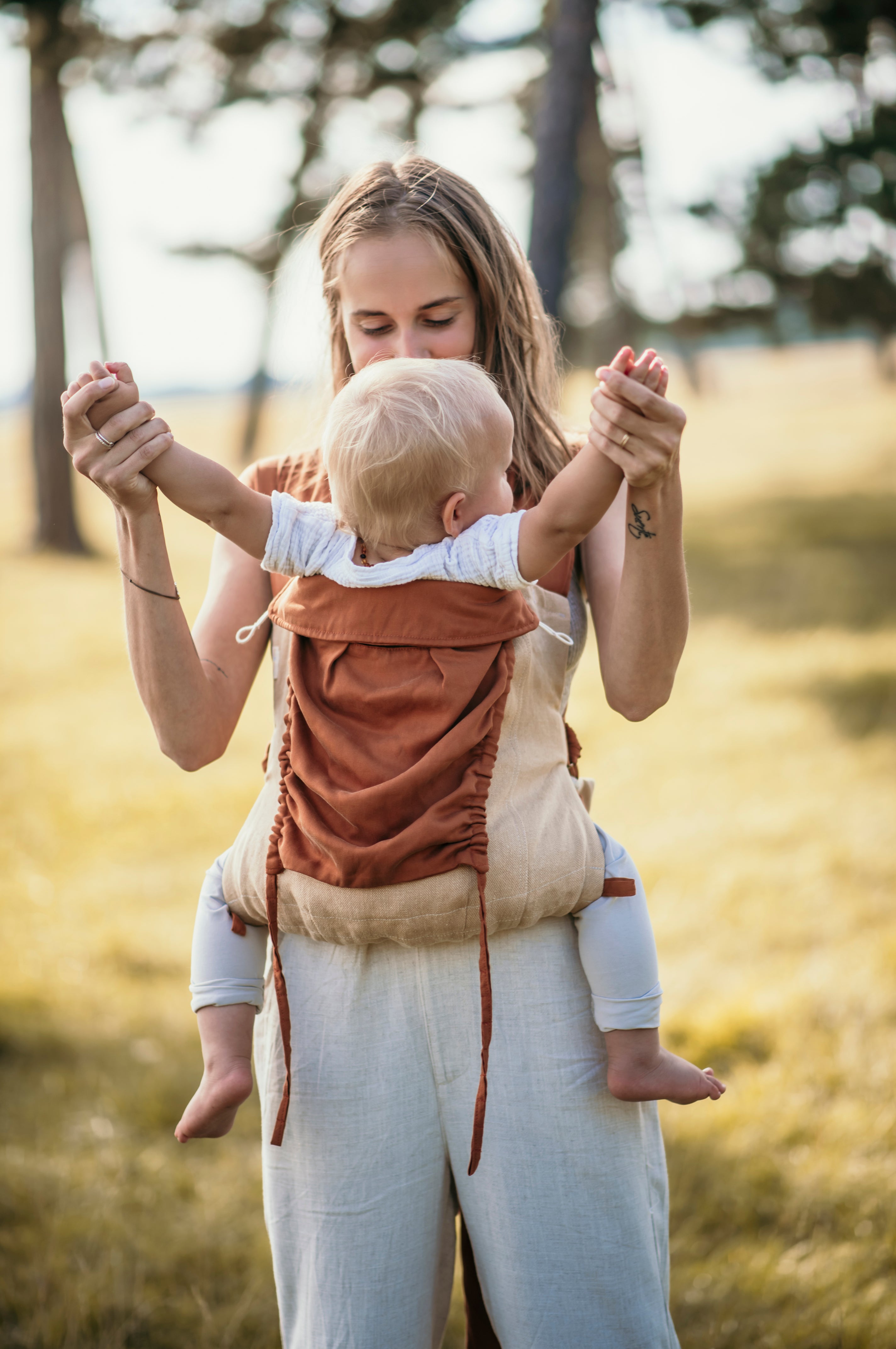 Mutter trägt Kind in Babytrage 