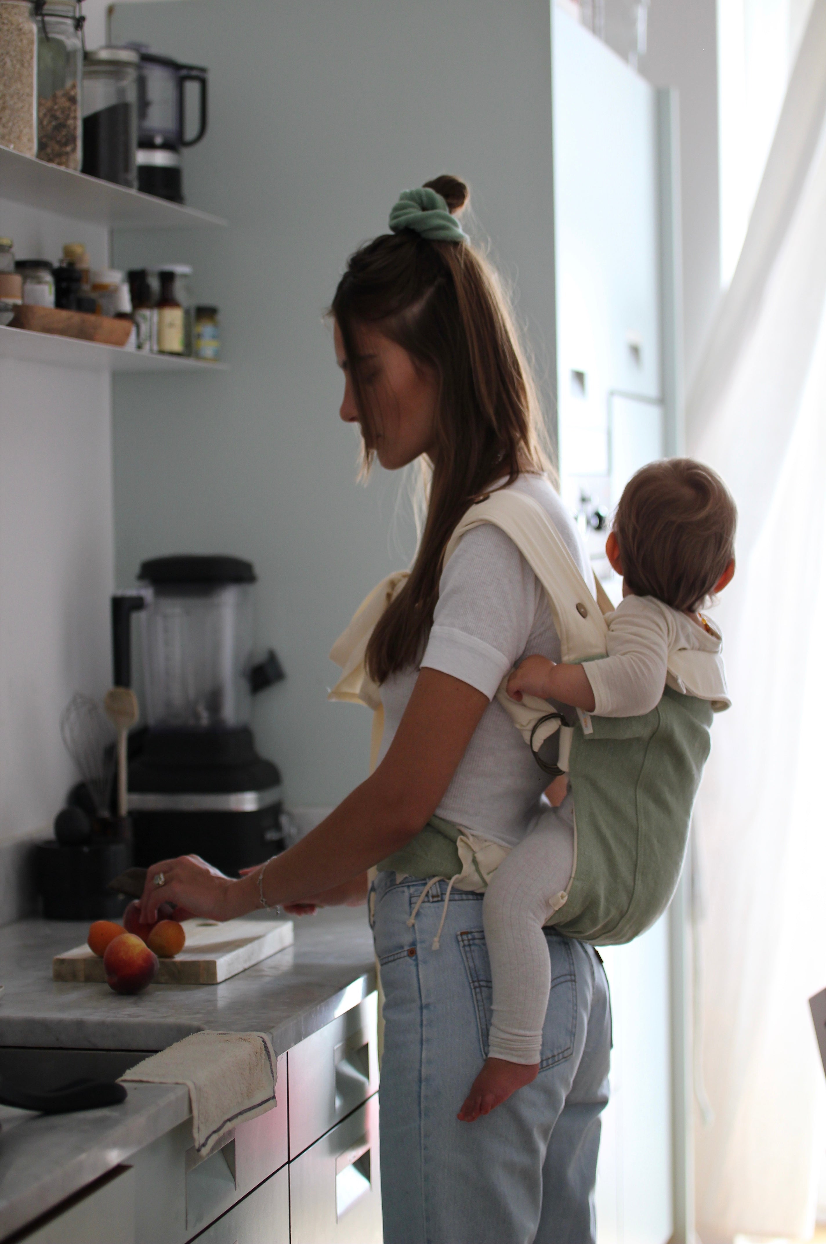 Mutter trägt Kind in Babytrage auf dem Rücken